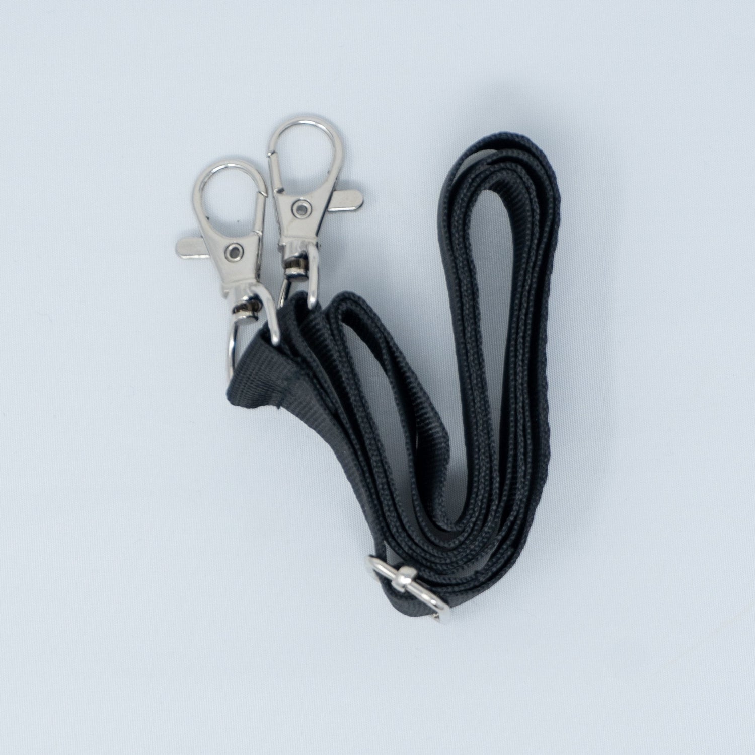 Black lanyard with metal clips on a light gray background