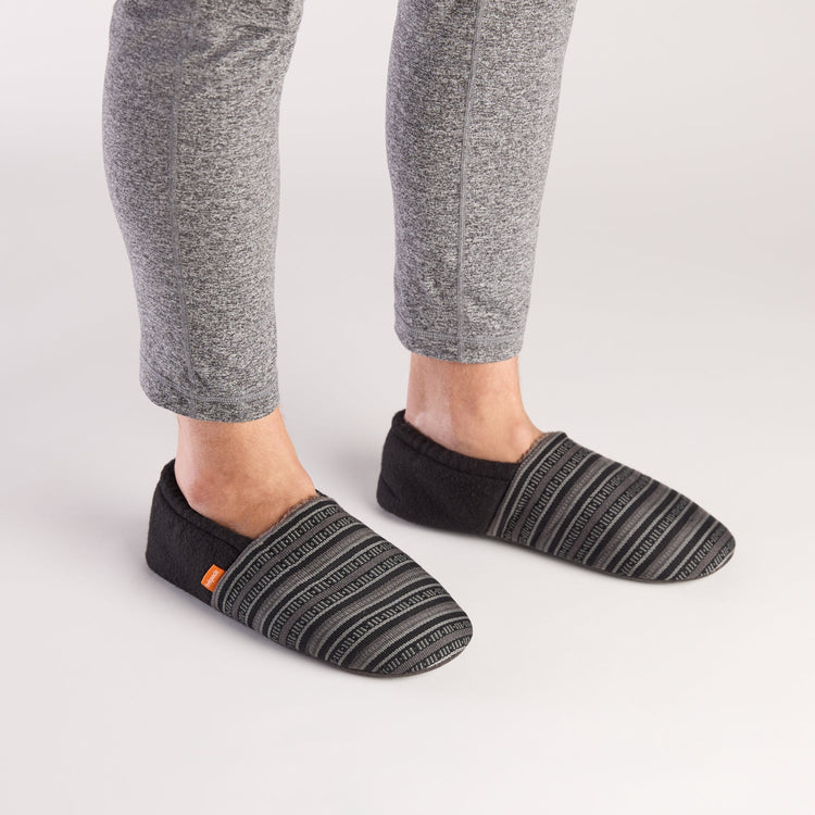 Person wearing black striped socks on a light gray background