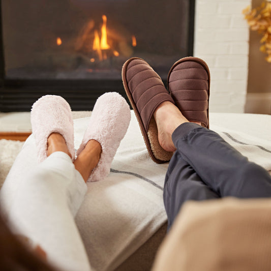 Pair of brown quilted slippers with beige lining on a white background