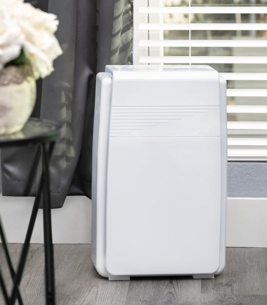 White air purifier on a wooden floor with a blurred background