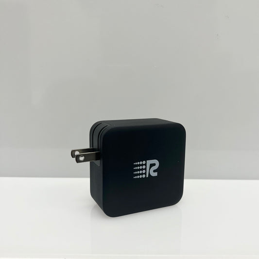 Black power adapter with foldable plug on a white background