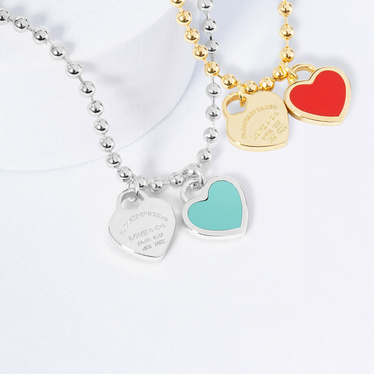 Three heart-shaped pendant necklaces on a white background