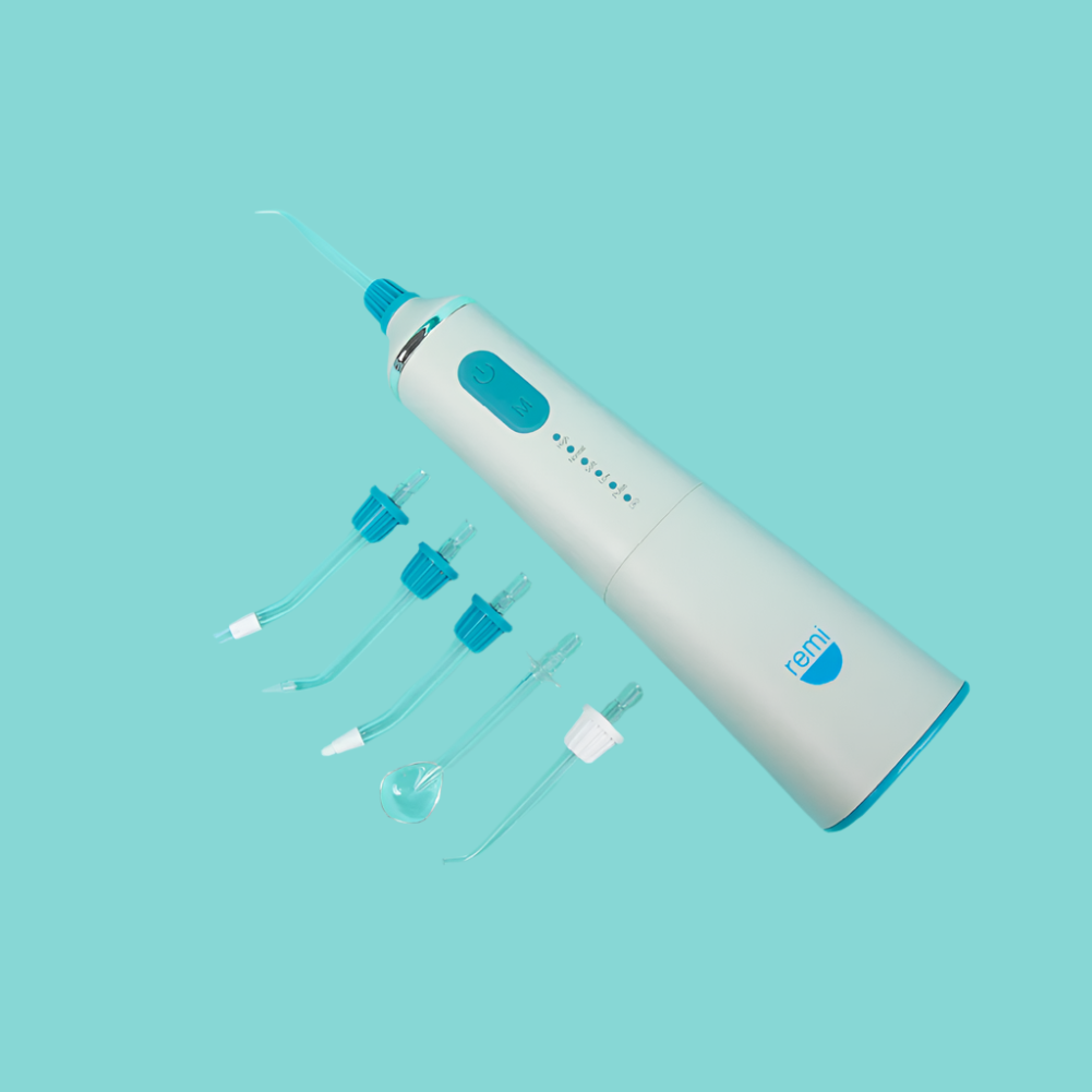 White and blue dental cleaning device with attachments on a light blue background
