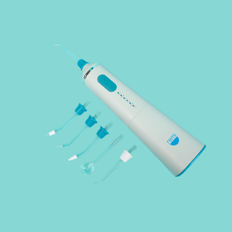 White and blue dental cleaning device with attachments on a light blue background