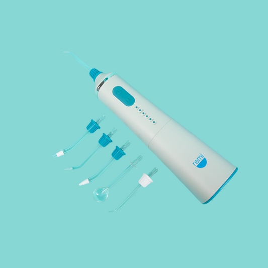 White and blue dental cleaning device with attachments on a light blue background