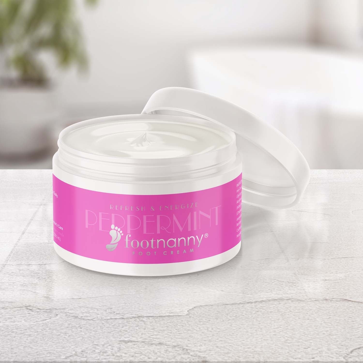 Jar of Peppermint Footnanny foot cream with pink label on a light surface.