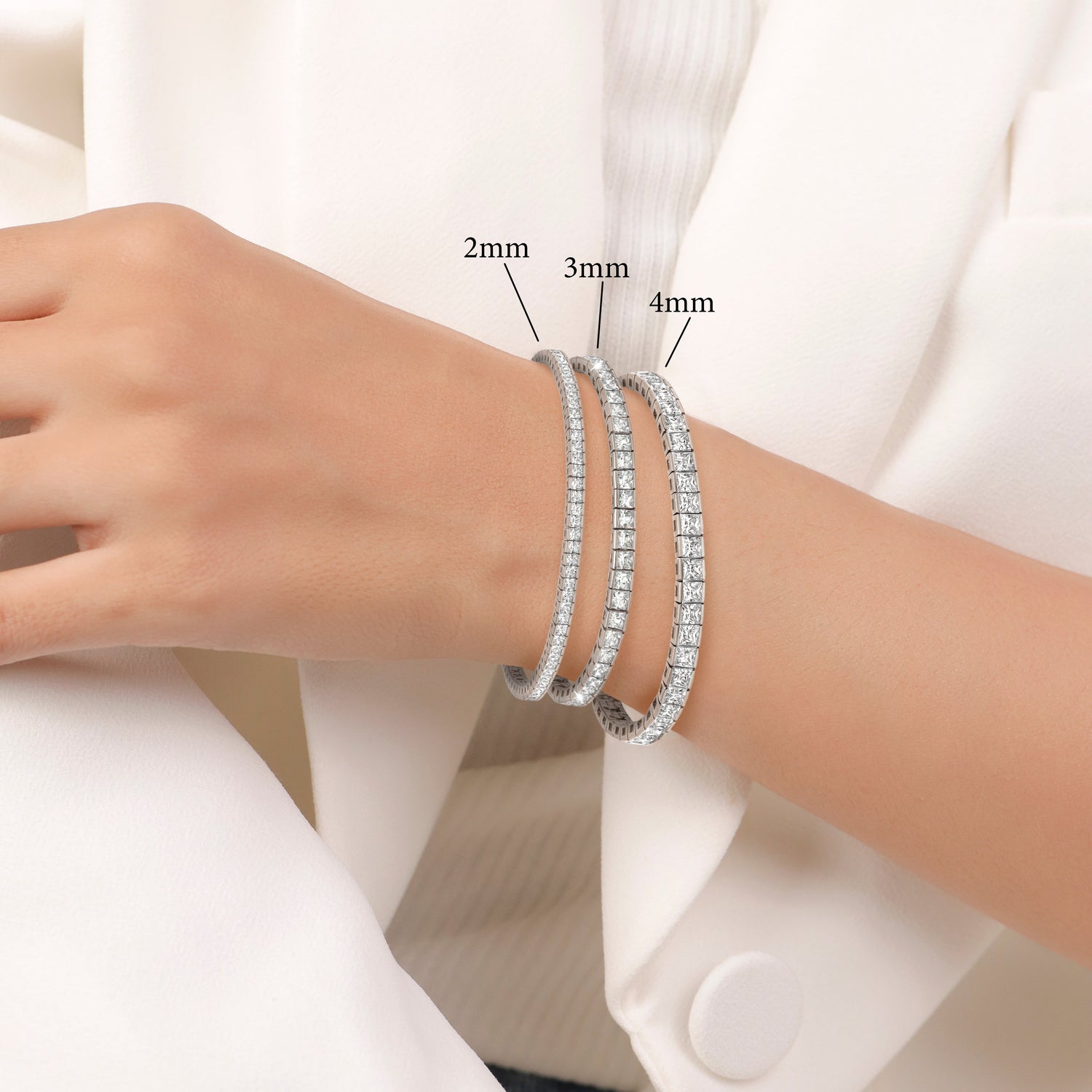 Silver beaded bracelets on a wrist with size labels