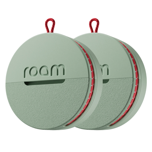 2-pack sage green Roam smart trackers with red elastic strap on transparent background showing compact round design with Roam branding