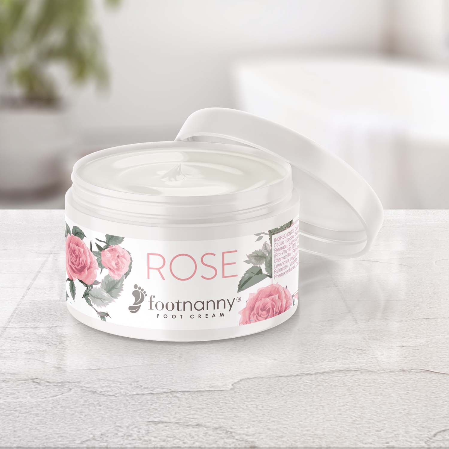 Footnanny Rose foot cream jar on a light wooden surface with a blurred background