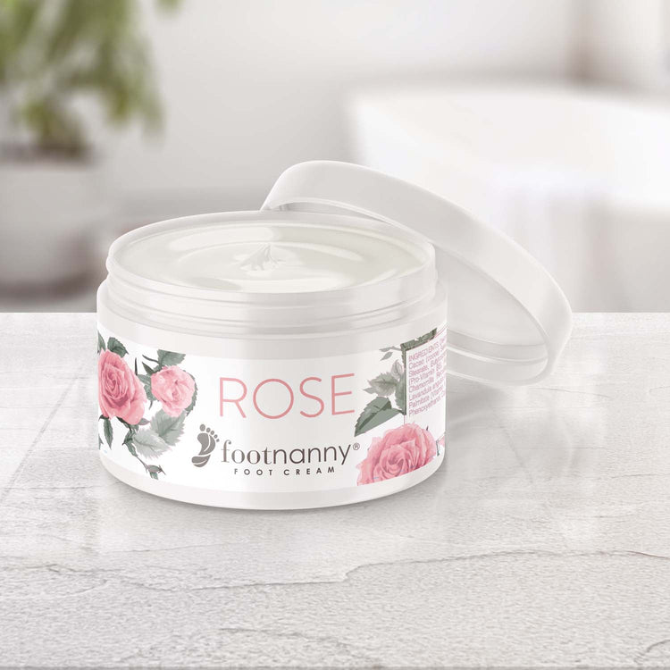 Footnanny Rose foot cream jar on a light wooden surface with a blurred background
