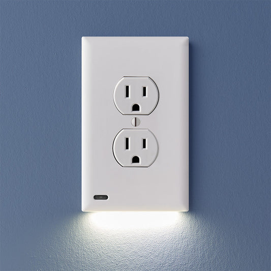 A white 2-pack of GuideLight outlet cover plates with built-in LED lights, mounted on a blue wall with the outlets visible at the bottom.