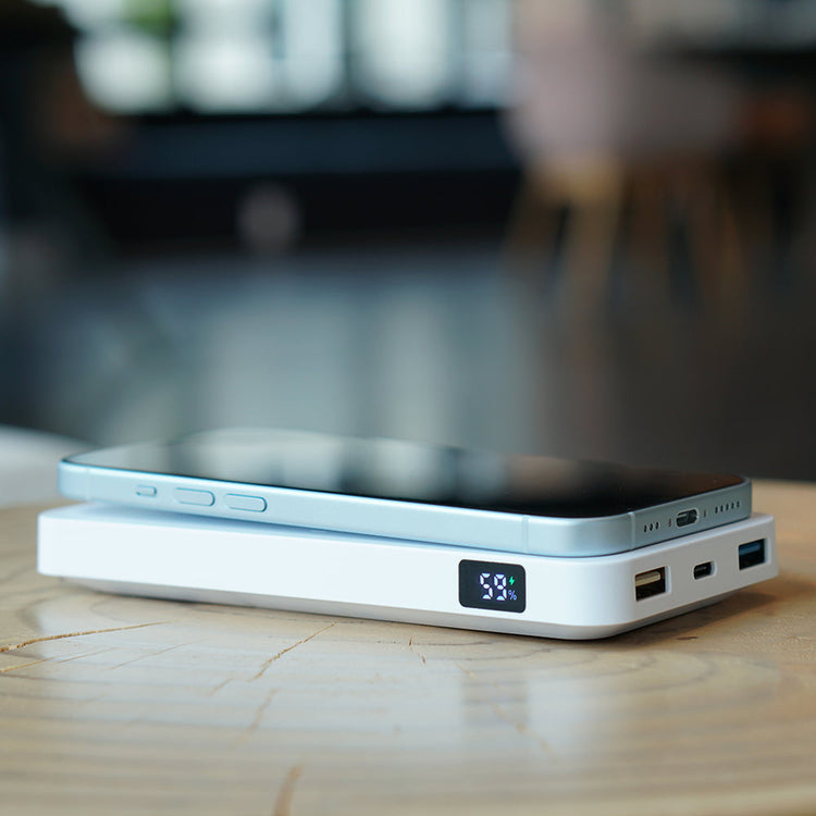 Portable power bank with smartphone on a wooden surface