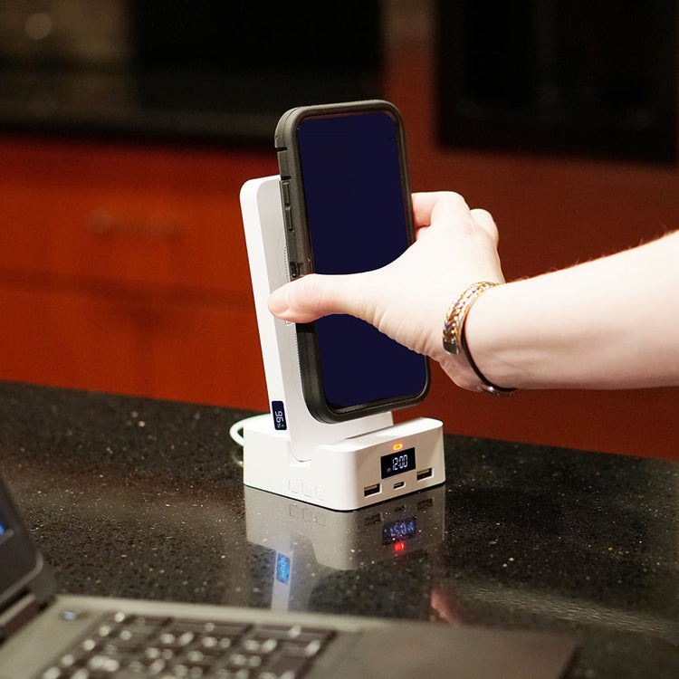Person using a smartphone on a charging station with a blurred background