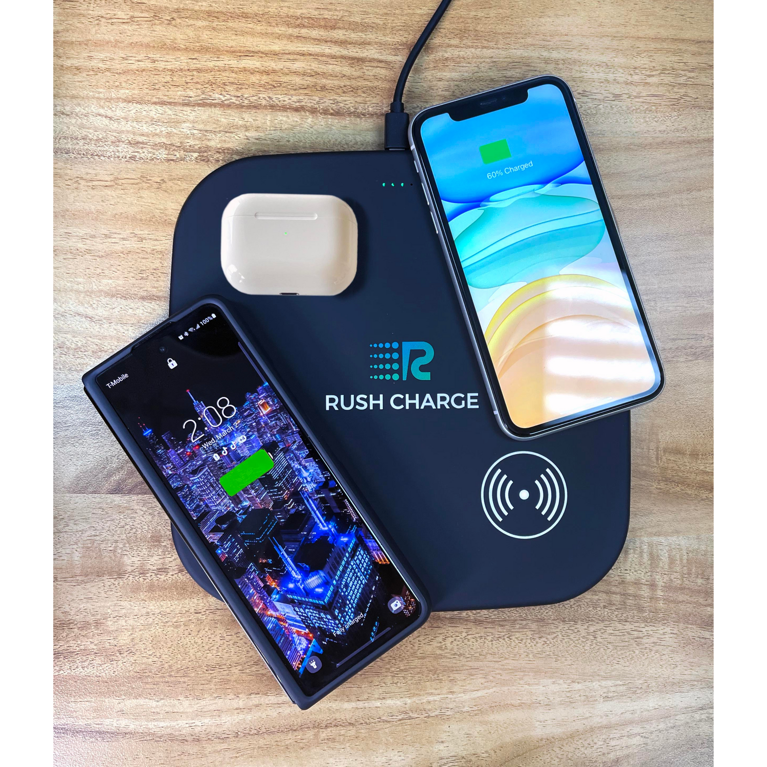 Wireless charging pad with two smartphones and a wireless earbuds case on a wooden surface, branded 'Rush Charge'.