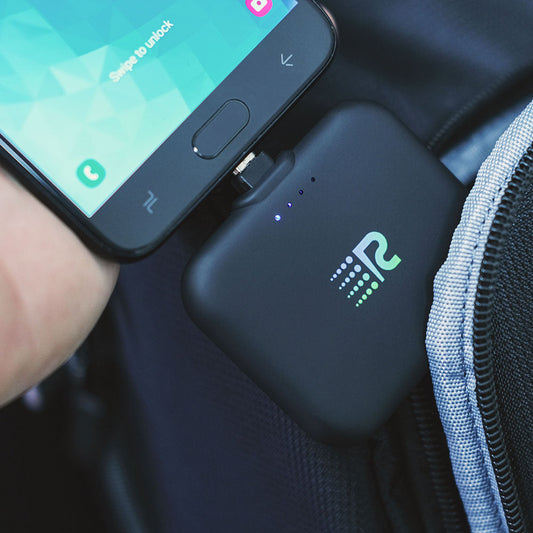 A compact and portable black charger with a logo on the front, featuring a single charging port.
